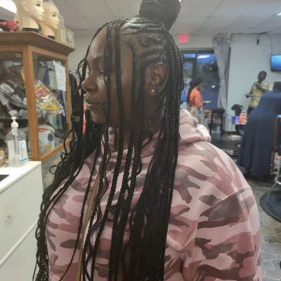 extra long braids with a brained bun near the top of a woman's head