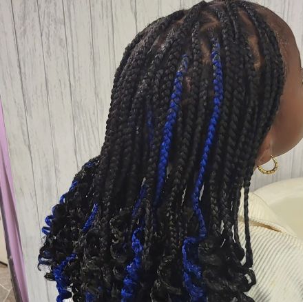 An image of a young lady with Poetic Justice braids, some are blue