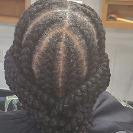 A close up of the back of a woman's head with corn rows
