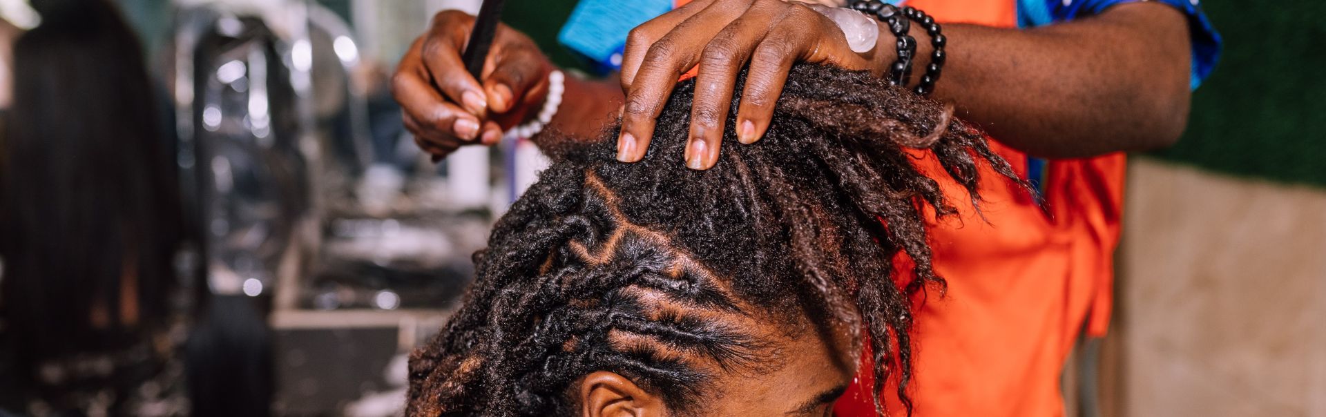 A close up of a woman getting corn rows